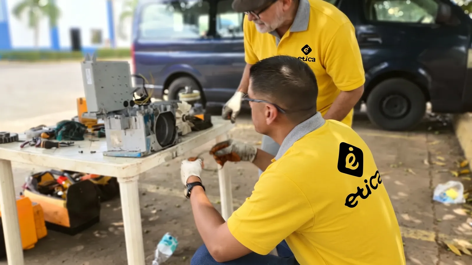 Técnico de E.T.I., C.A. trabajando sobre un equipo en el patio del taller